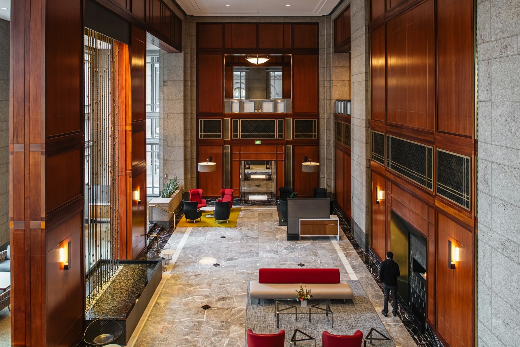 Elevated view across a polished commercial lobby with wood paneling and stone floors